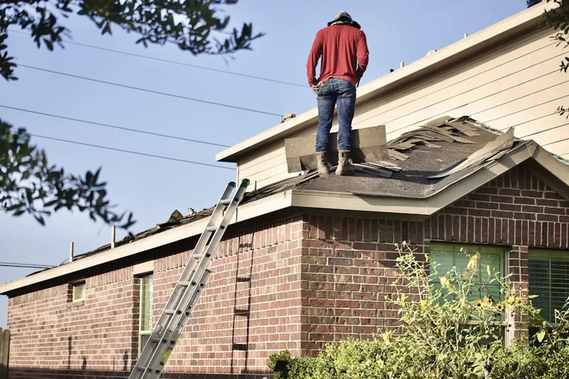 Professional roofer working on a residential roof in Hudson Falls
